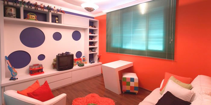 No playroom, o móvel com nichos vazados e a cor branca foram utilizados em contraponto com as cores das paredes. Foto: Adriane Xavier